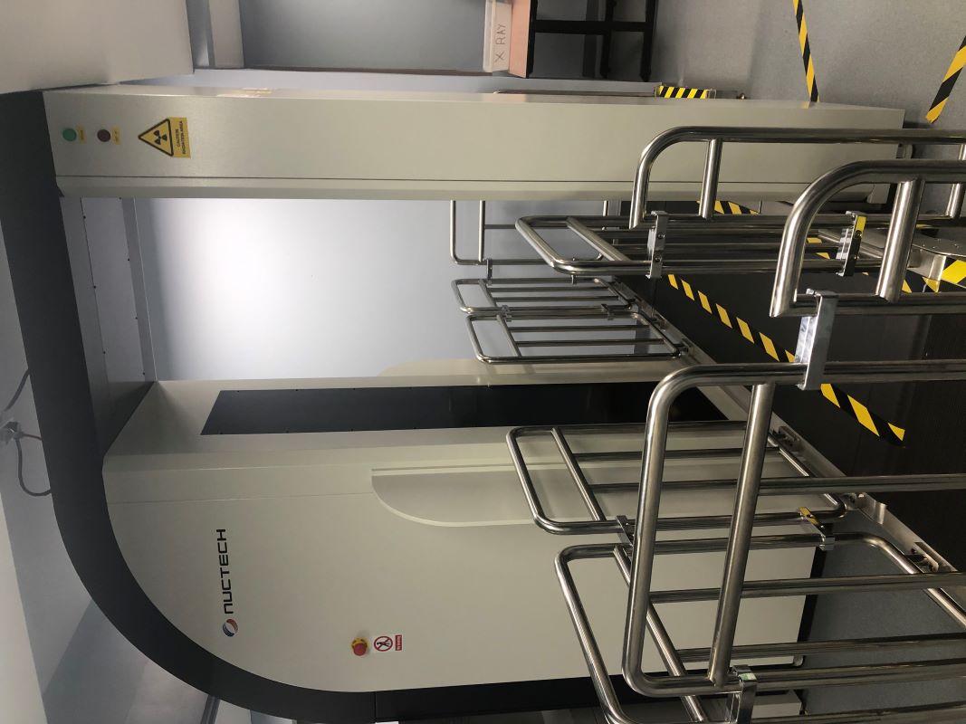 Metal railing around a raise platform through a large white machine