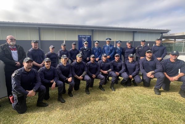 Officers kneeling in a row in front of senior executives