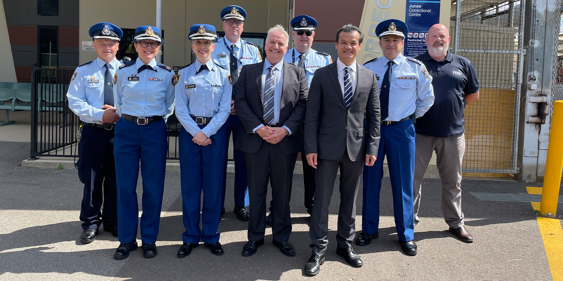Corrective Services Minister, Commissioner, officers and staff standing in front of Junee Correctional Centre