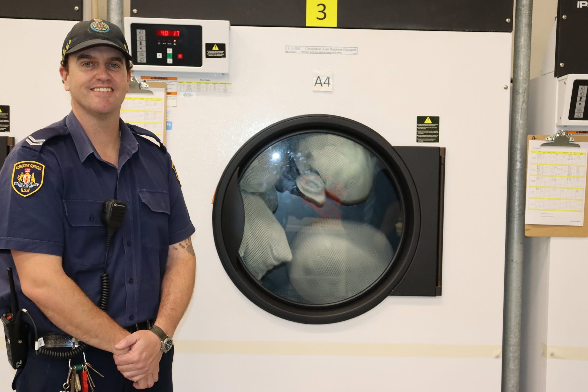 Man standing beside a large industrial washing machine