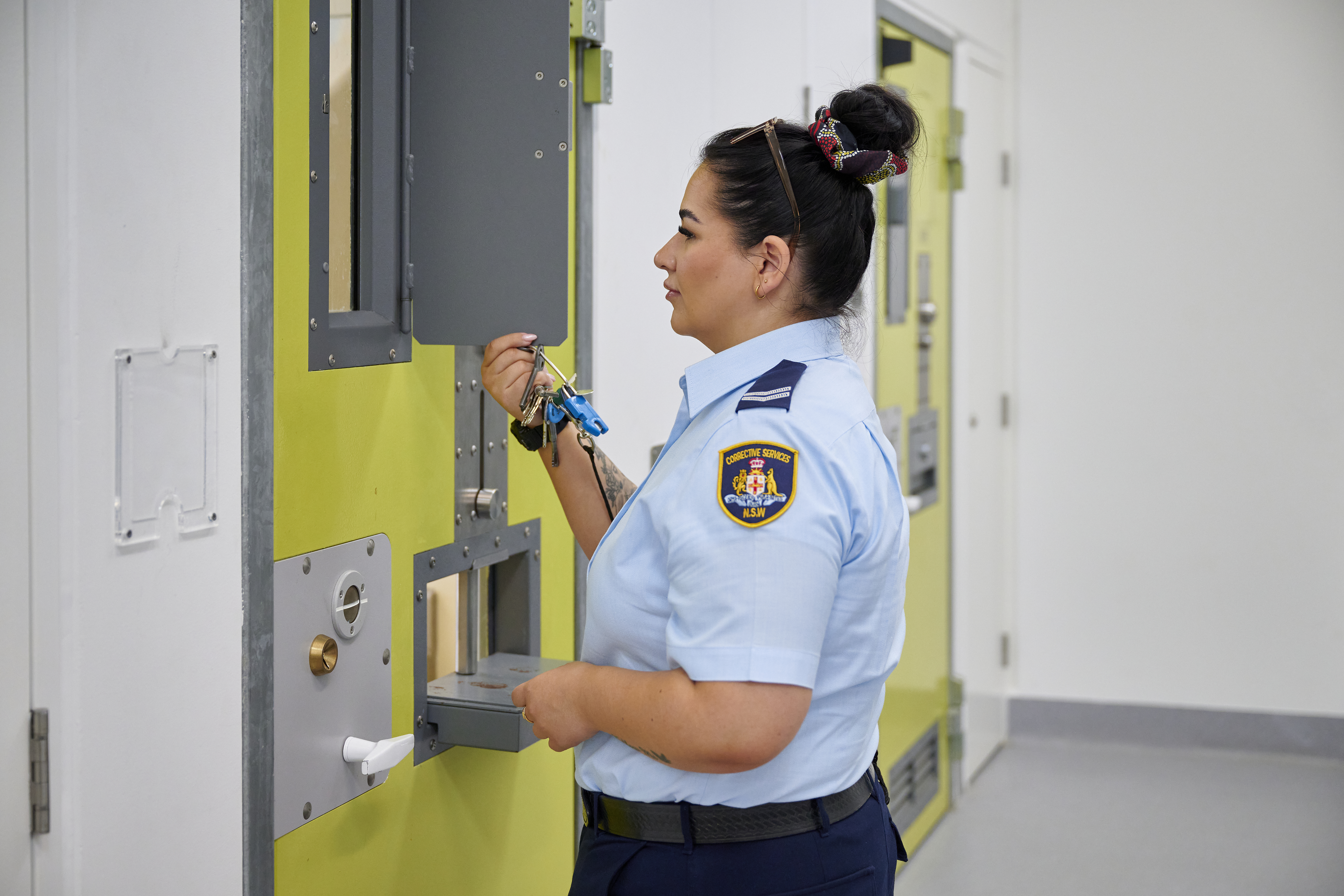 An image of a female Correctional Officer checking a cell